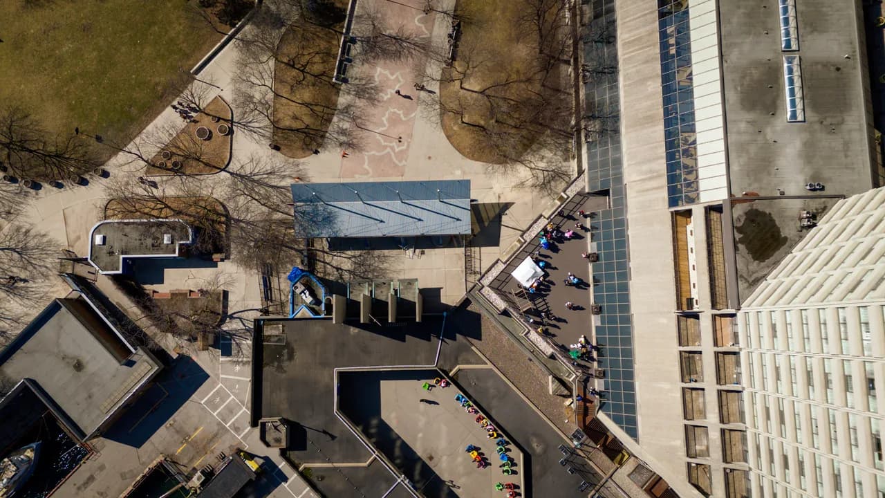 A straight-down view reveals angular rooftops, paved courtyards and long building shadows. Coast & City photo 11 of 11.